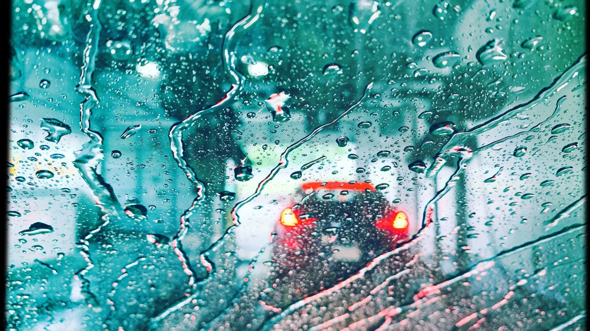 Car going through car wash with water droplets on windshield